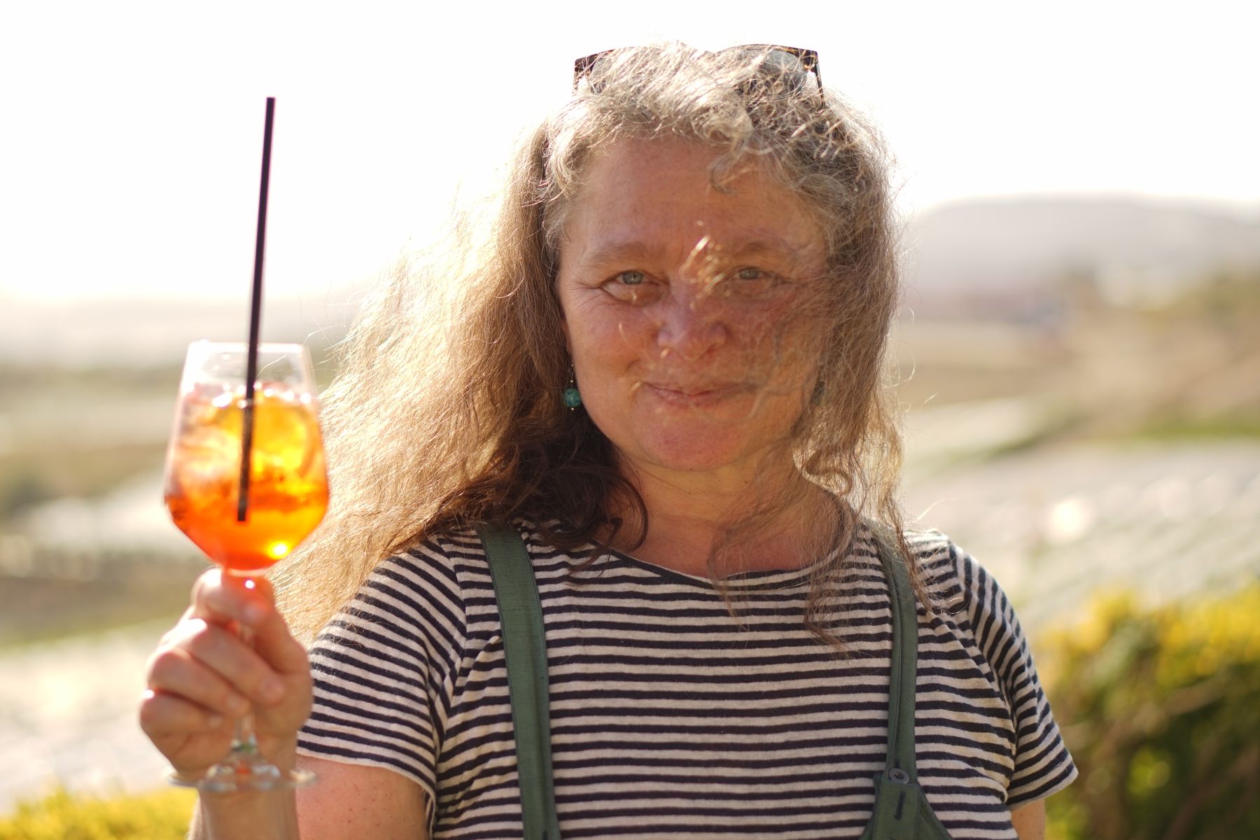 Anita vom Grünland präsentiert Aperol, im Hintergrund italienische Landschaft